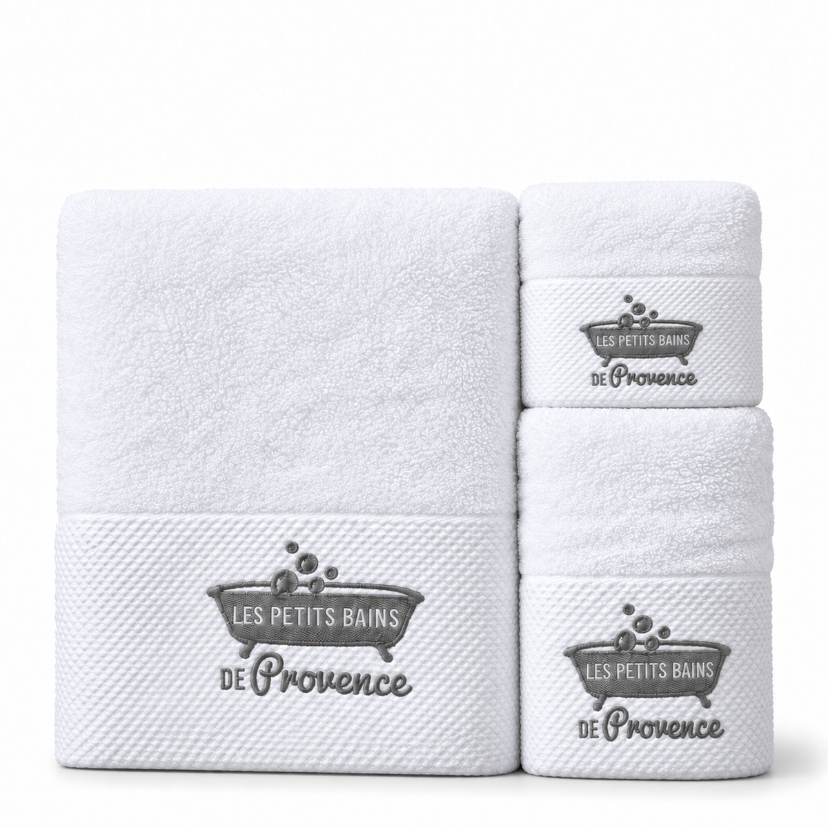 Les trois serviettes blanches brodées, grande à gauche et deux petits formats à droite